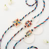 Gift Pearl And Meena Work Rakhi Set Of 3 With Assorted Laddoos