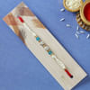 Buy Pearl Rakhi with CZ Stones & Blue Beads