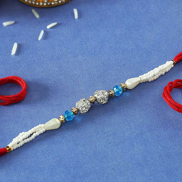 Pearl Rakhi with CZ Stones & Blue Beads