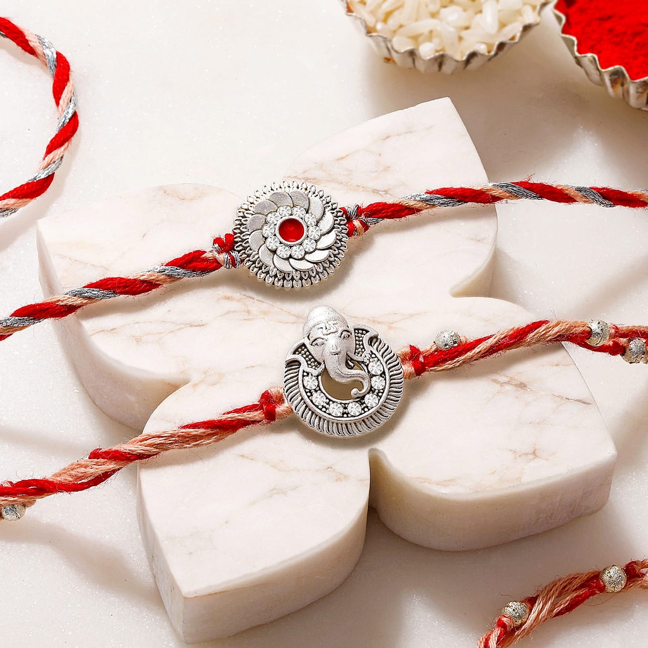 Silver-Plated Ganesh and Floral Rakhi Set of 2